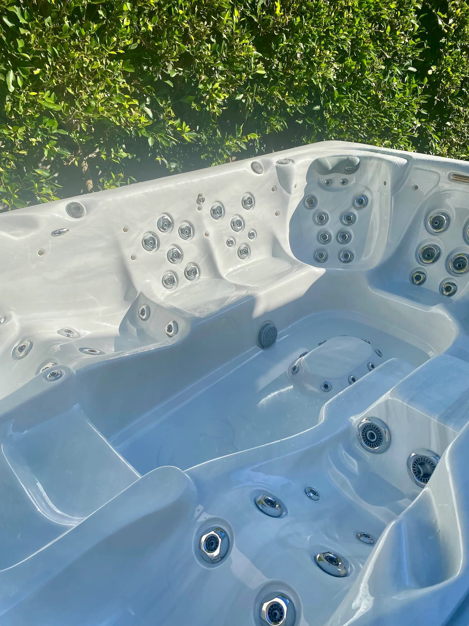White hot tub interior with multiple chrome jet fixtures installed in acrylic basin